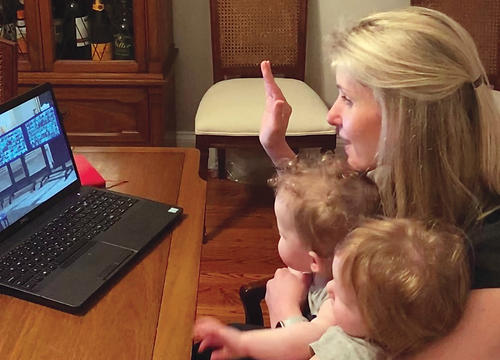 Alicia Molt-West takes her oath of office via computer, with her twin daughters seated on her lap