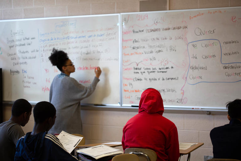 a student teacher writing on a whiteboard during class 