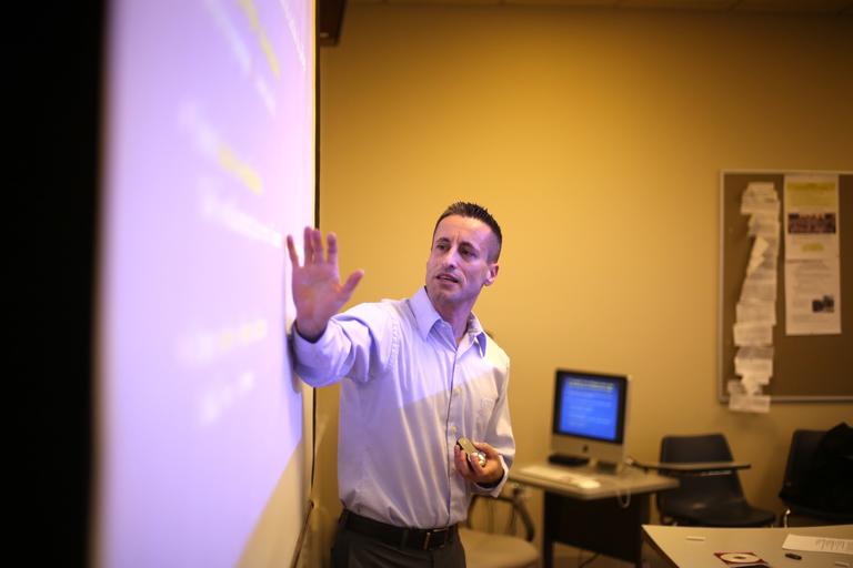 Teacher pointing to a digital presentation screen