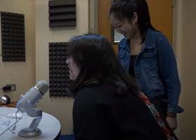 Young woman leaning into use Blue Yeti microphone