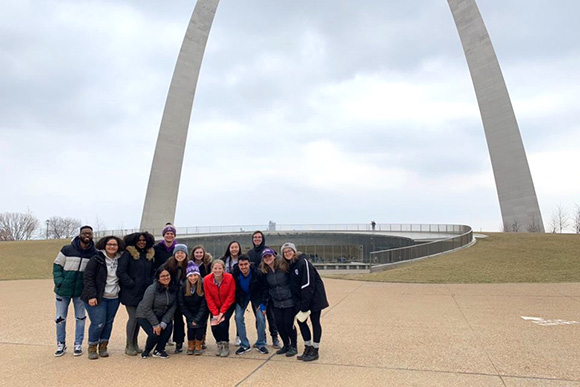 Students standing in front of the Gateway Arch in St. Louis as part of an immersion program.