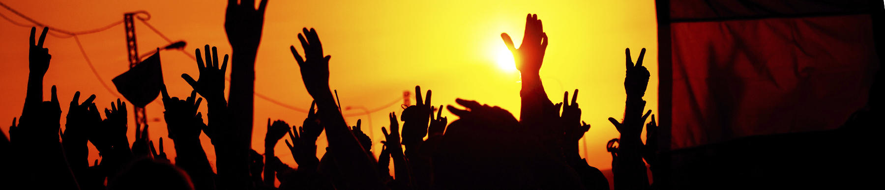 people with their hands in the air over a sunset