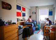 two students sitting on their beds chatting in their room in Wheeler Hall
