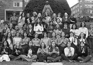 A black and white photo from the 1970s of a group of about 40 women posing with their hands in prayer and some are looking to the sky.