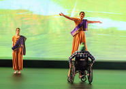 Jasmine 3 dances with Bud in his wheelchair while Jasmine 2 looks on.