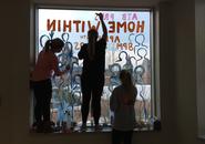 Maria Claudia, Mickenzie, and Margaret work on a window display to promote "Home Within"