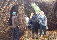 Mickenzie Kamm gives Holy Cross visitors a tour of Patrick Dougherty's "Stickwork" Sculpture, explaining the creation process