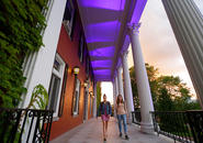 Students walk on the Fenwick porch, which is lit purple for the occasion. Photo by Tom Rettig