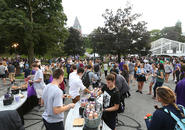 A crowd of people decorate donuts at one of the many food stations. Photo by Tom Rettig