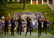 The Rhythm Nation Steppaz perform in front of a large Holy Cross 175th logo. Photo by Tom Rettig