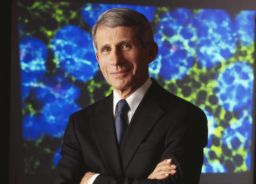 Dr. Anthony Fauci stands before a blue background