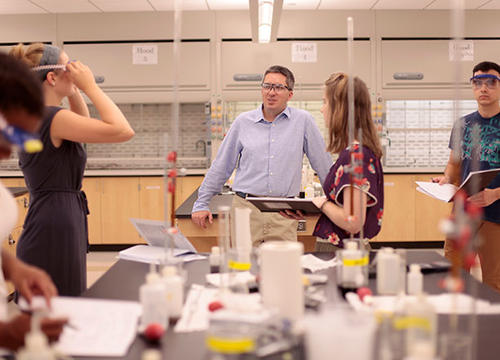 Kenneth Mills stands with students in his lab