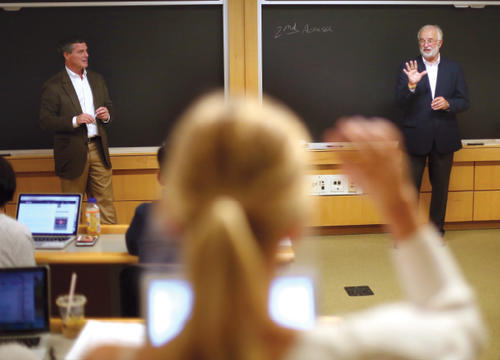 Peter Flaherty '87 and Tim Bishop '72 stand at the front of the classroom