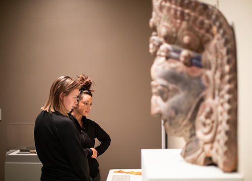 Holy Cross students are seen here admiring the objects of Buddhist devotion displayed in the Cantor Art Gallery's Dharma and Punya exhibit. Photo by Avanell Brock