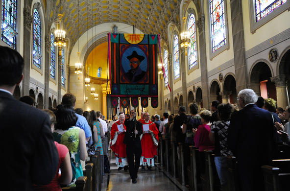 Jesuit holds a banner of St. Ignatius of Loyola, founder of the Jesuits, as he and other clergy members process out of St. Joseph Chapel