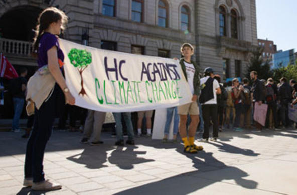 students hold up sign that reads “hc against climate change” at climate strike outside worcester’s city hall