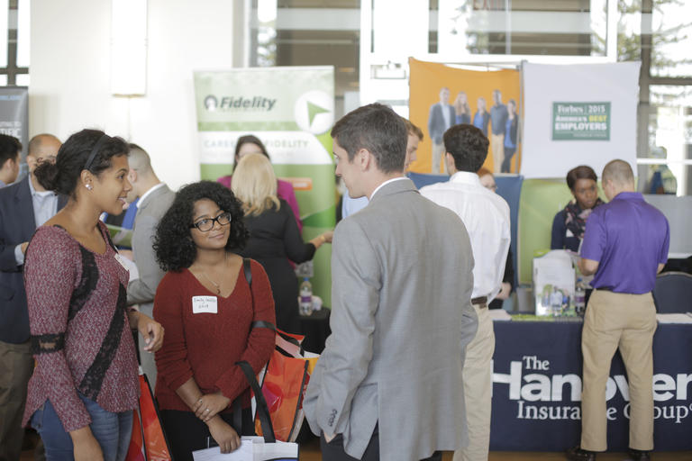 students interacting with a recruiter at a career fair