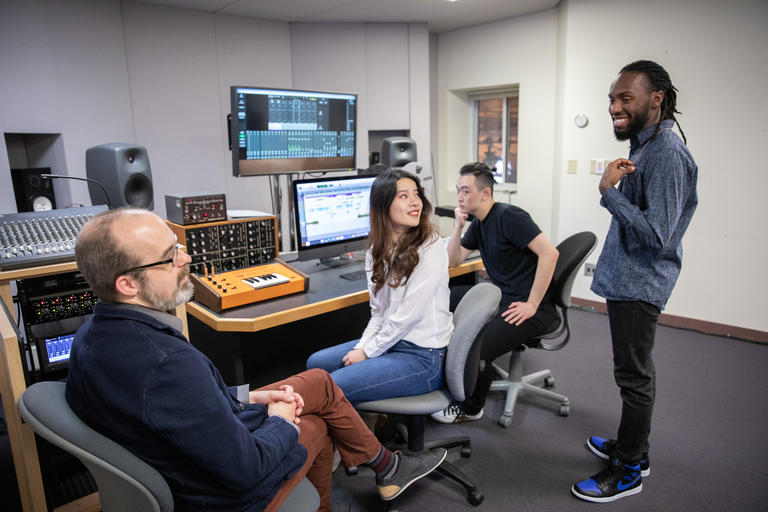 students and a professor interacting in an audio lab