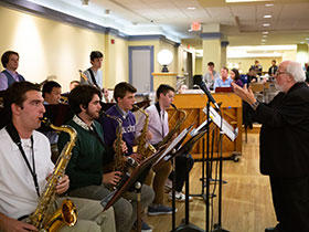 Holy Cross Jazz Ensemble performs with conductor leading them.