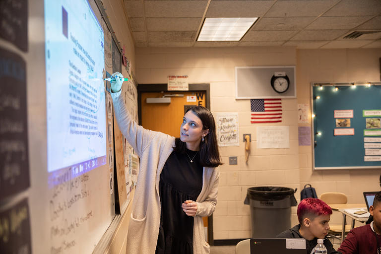 Hannah Trueman, TEP '19, writes on the whiteboard in her classroom at Sullivan Middle School in Worcester.