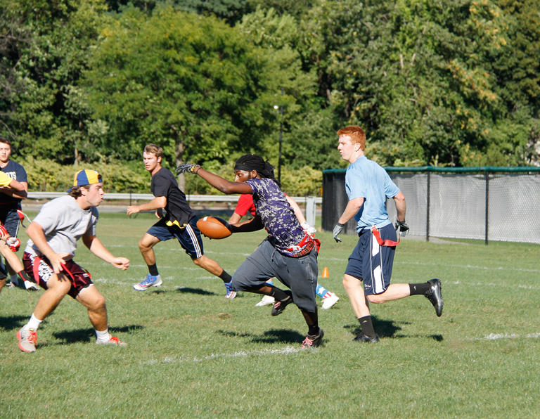Students playing flag football on a sunny day