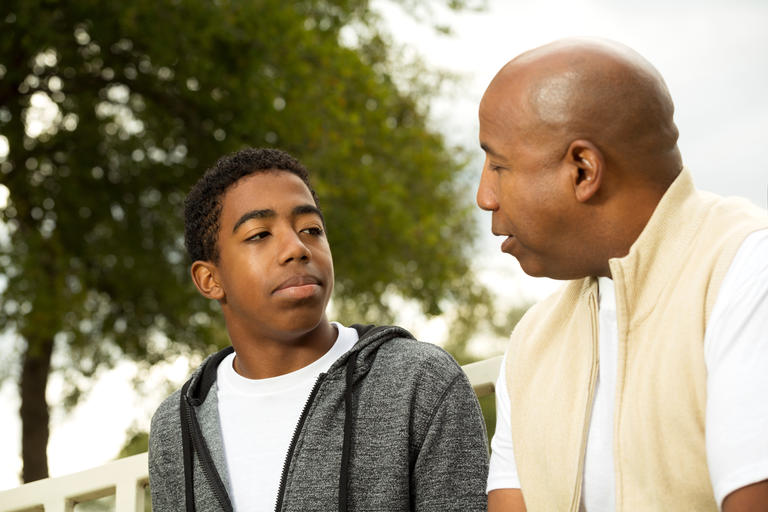 A father having a serious discussion with his young adult son.