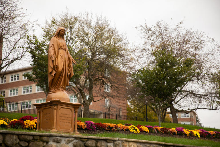 Campus statue with residence hall in background