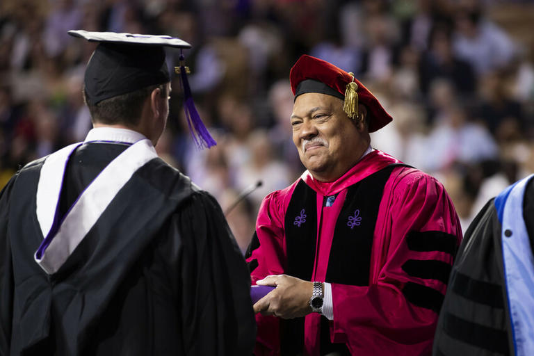 President Rougeau shaking graduate hand on commencement stage