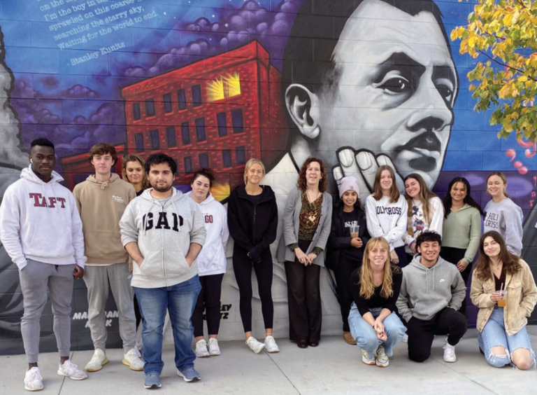 Professor Sweeney and students in her fall 2022 Poetry & Poetics class in front of a mural of the late Worcester poet Stanley Kunitz at Polar Park