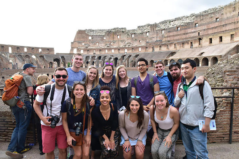 a very large group of students posed in a roman amphitheater