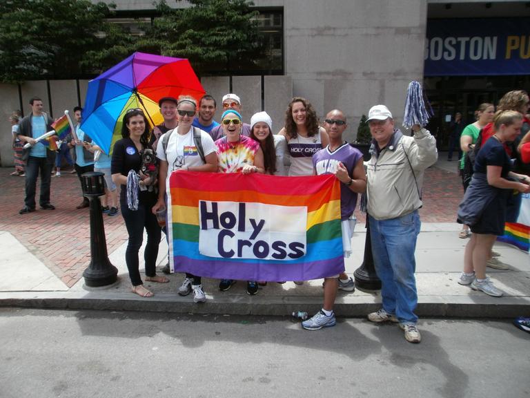 Group of people outside holding rainbow flag