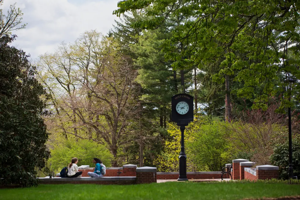 Two students talk underneath the Holy Cross clock