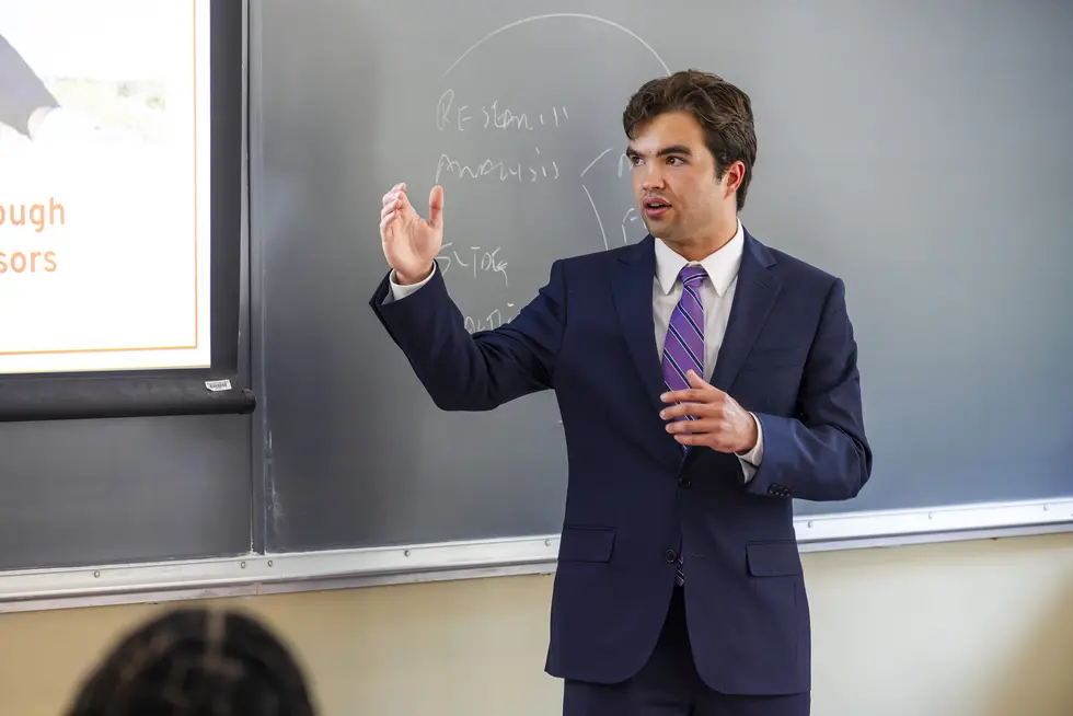 Business student giving a presentation in front of a class.