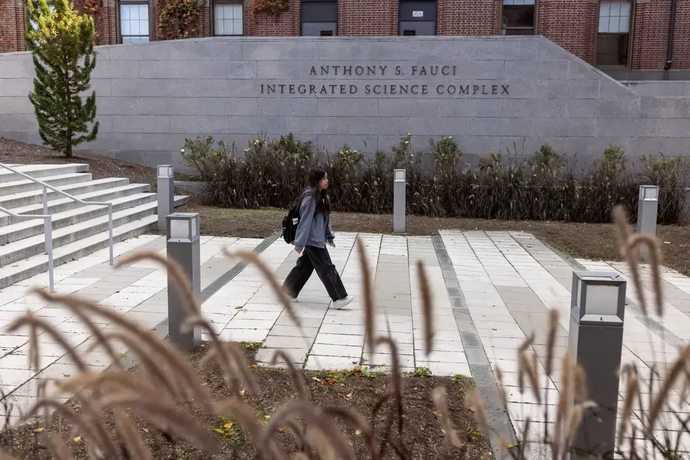A student walks through the Anthony S. Fauci Integrated Science Complex
