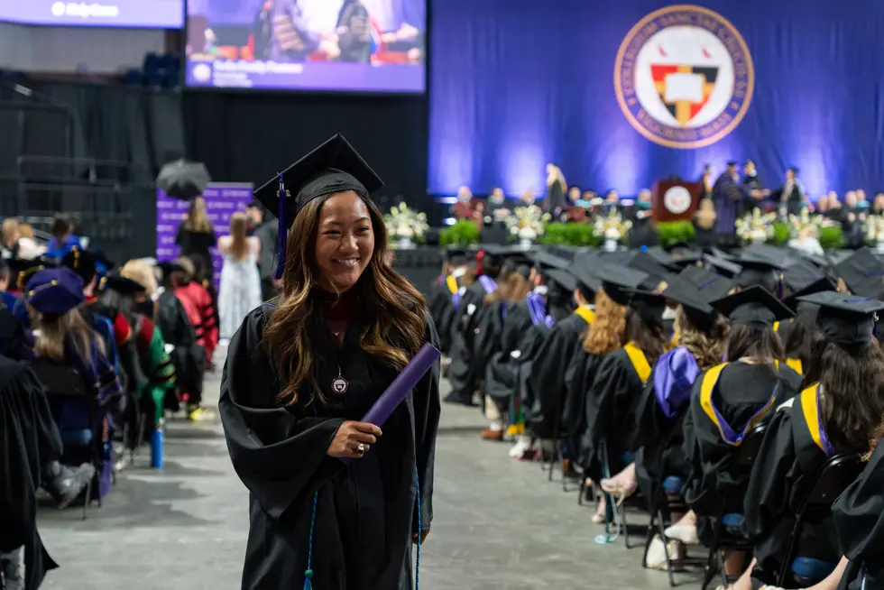 A student receives their diploma at Holy Cross commencement 2026