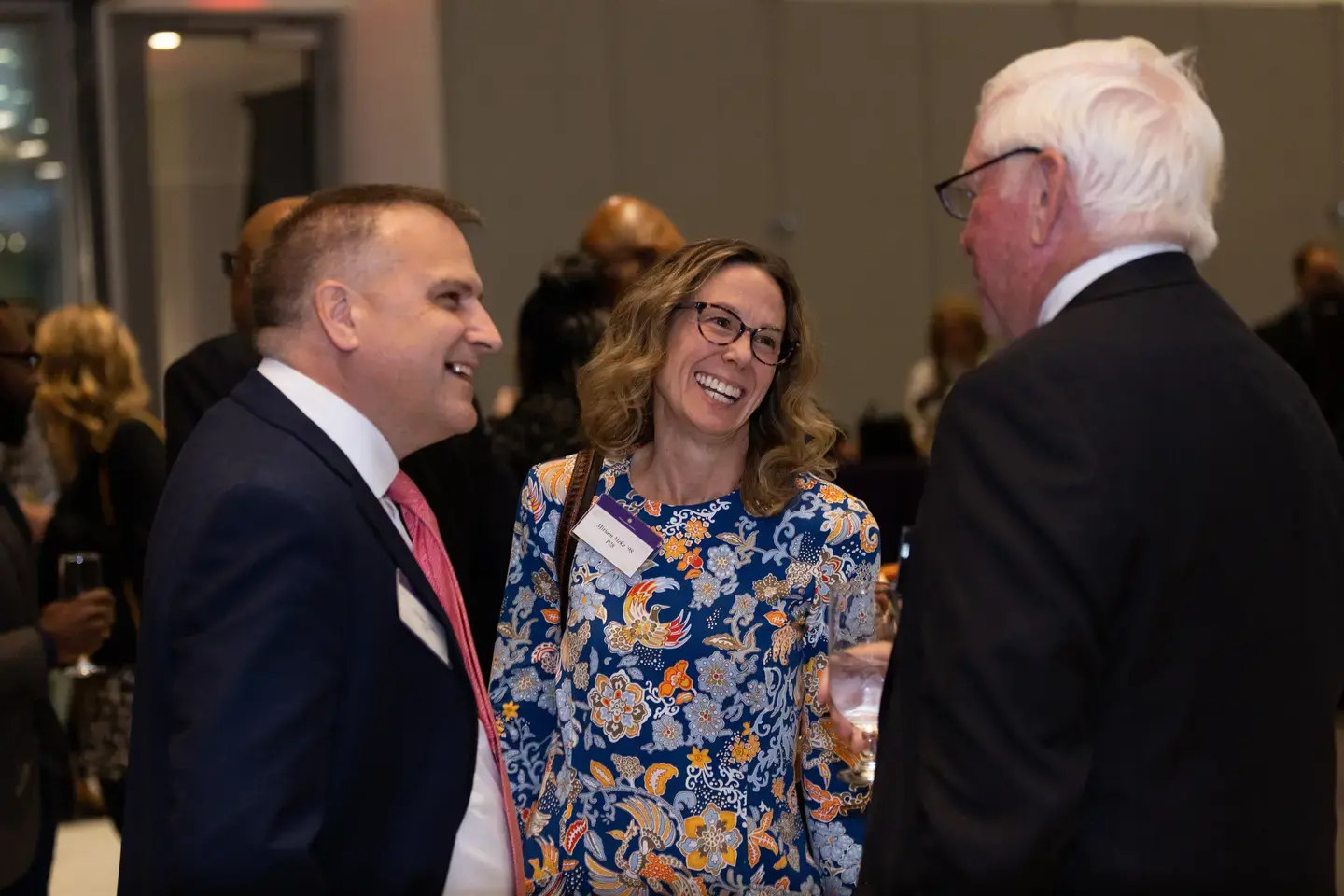 three people talking at a reception