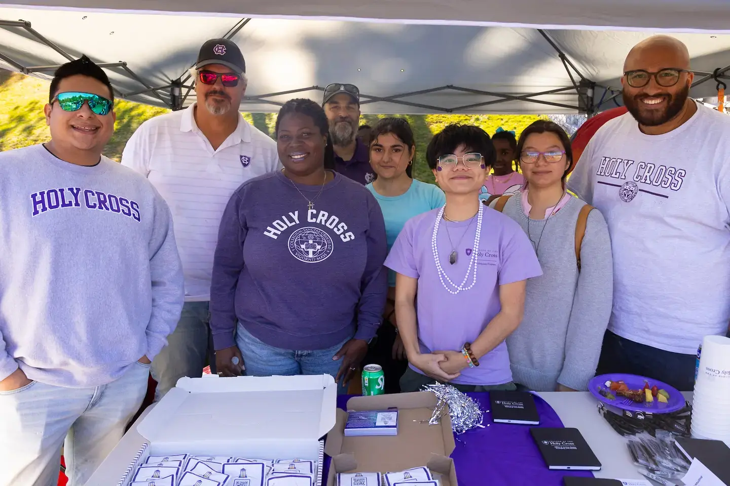 a group of people wearing purple at a tailgate