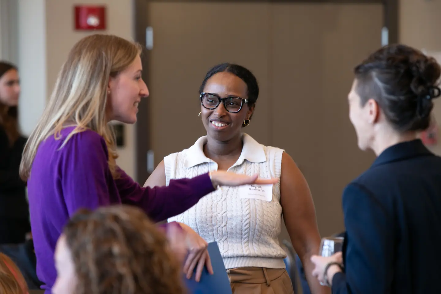 People conversate in a group at an alumni event.