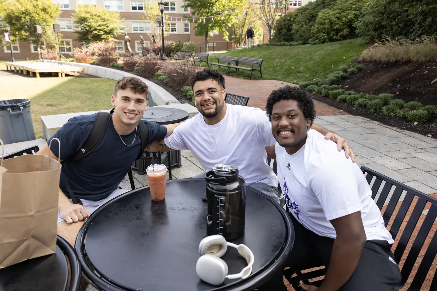 A group of students gathered around a table on the Hoval at Holy Cross pose for a photo
