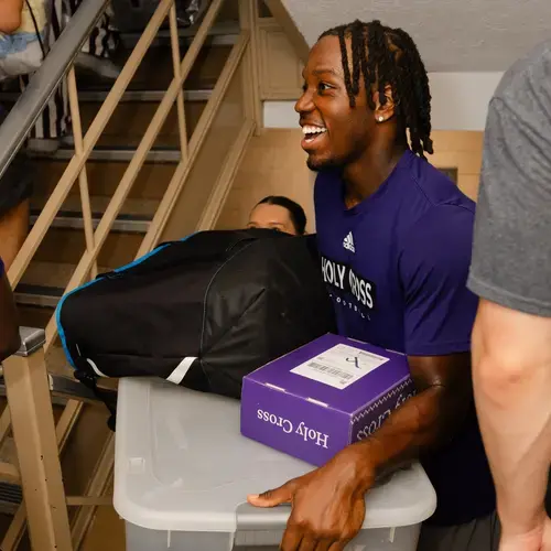 A student moves items up the stores of a dorm during move-in day 2026