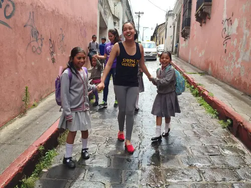 Student holding hands with 2 children during semester immersion program