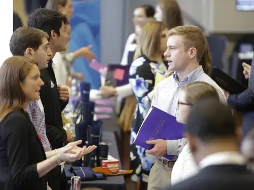 people at a conference talking across a table