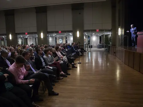 an audience facing a stage in a large ballroom