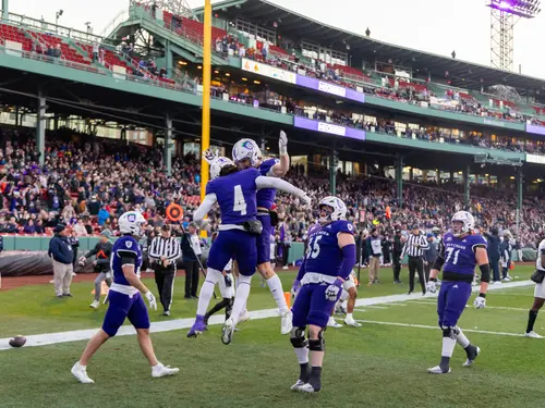 Holy Cross football players celebrate a touchdown during a game played at Fenway Park.