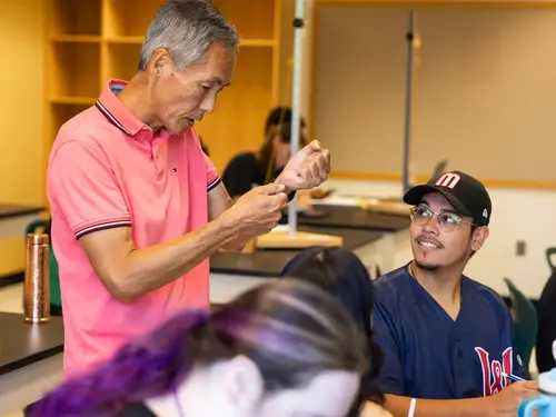 Professor Tom Narita in a classroom discussion with a Holy Cross student