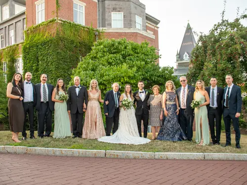 A wedding party poses for a photo on the campus of Holy Cross