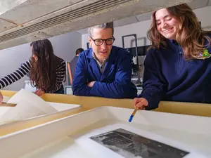 A dark room photography student and professor discuss their work.