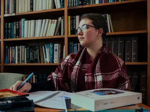 Eowyn Bailey at a table in the library writing in a notepad
