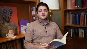 Young man with book at desk
