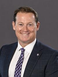 athletic director kit hughes close up picture man in a suit with holy cross pin